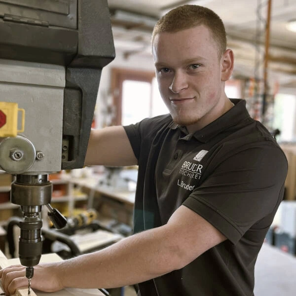 Tischler bedient Standbohrmaschine in Werkstatt, Holzverarbeitung und Handwerk